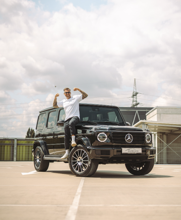 Sven Knobloch steht am Rand und Reifen eines Mercedes G400 d